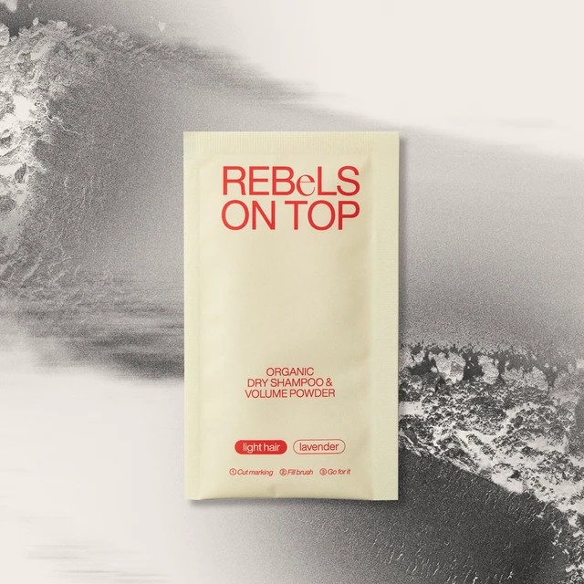 Bio-Trockenshampoo-Nachfüllpäckchen in Beige für helles Haar, platziert auf einem Hintergrund aus losem Pulver