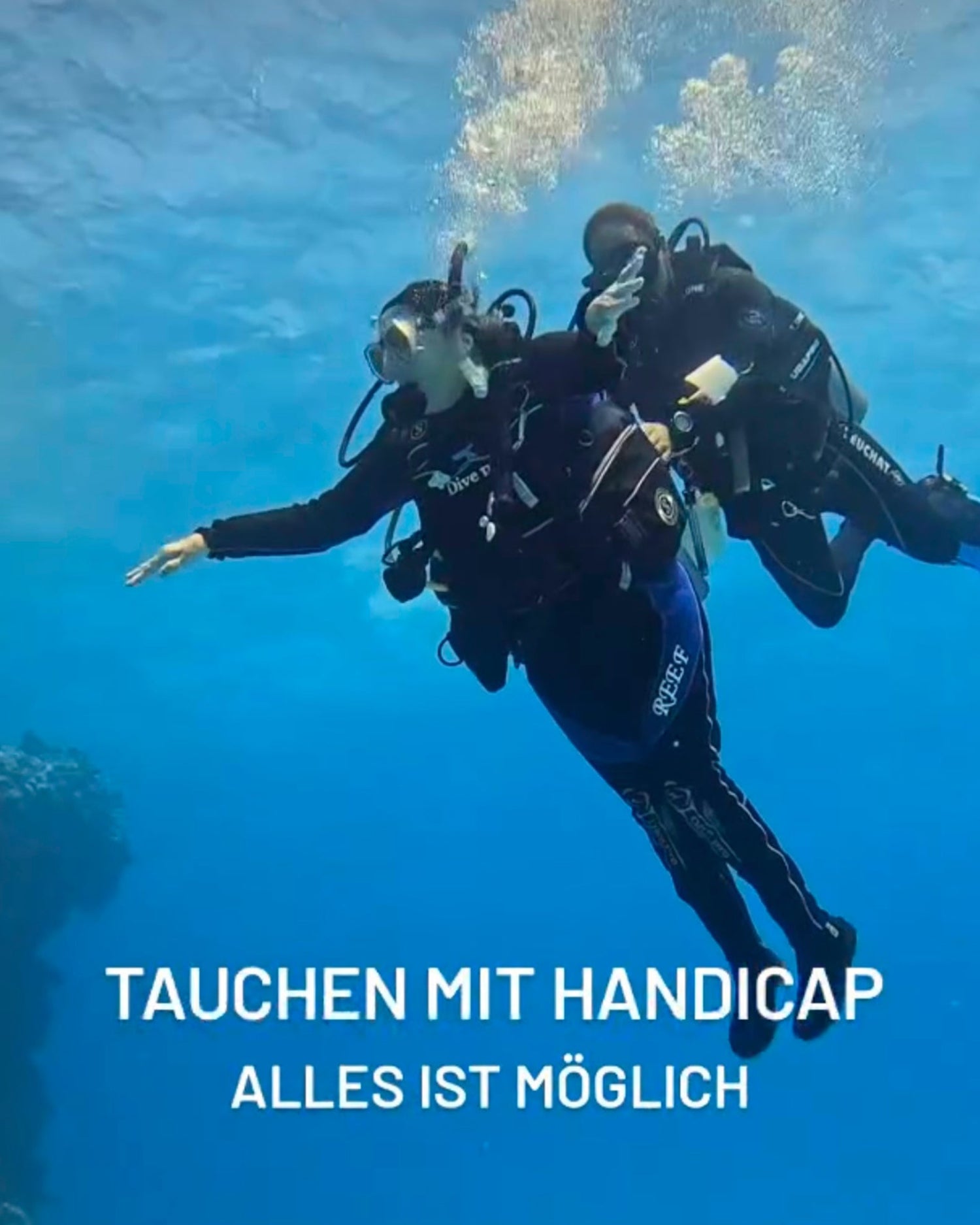 Zwei Taucher:innen unter Wasser – eine Person unterstützt die andere von hinten beim Schweben. Darüber steht der Schriftzug: Tauchen mit Handicap – alles ist möglich. Das Bild vermittelt Inklusion, Leichtigkeit und Gemeinschaft im Wasser.