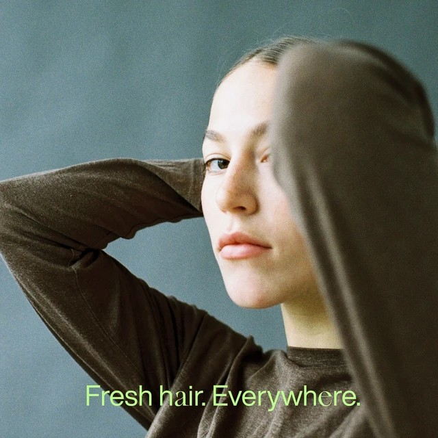 Minimalistisches Werbebild für REBeLS ON TOP – Frau mit zurückgelegten Armen. Slogan ‚Fresh hair. Everywhere.‘ in grüner Schrift.